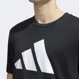 Remera de entrenamiento Adidas, color negro, con cuello redondo y manga corta. Presenta el logo Badge of Sport de Adidas en grande en el frente, compuesto por tres barras blancas en forma ascendente.