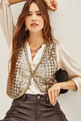 Chaleco corto con diseño de lentejuelas brillantes en tono dorado y plateado. Presenta un corte clásico con bordes definidos y forro interior suave.