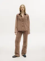 Campera de denim con efecto gastado, cuello camisero, cierre frontal con botones metálicos y corte holgado. Presenta canesú con costuras decorativas en el frente y la espalda, y botones en los puños.