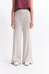 Pantalón de punto color beige, con diseño calado, cintura elástica y corte palazzo.