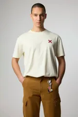 Remera color crema de manga corta con logo bordado en el pecho.