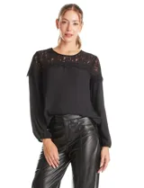 Blusa de gasa negra con canesú de encaje en el frente y la espalda, manga larga con puño elastizado y cierre de botones perlados en la espalda.
