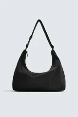 Bolso de hombro tipo hobo fabricado en tejido técnico de nylon. Cuenta con un compartimento principal con cierre de cremallera, un bolsillo interior con cierre y un asa ajustable con detalle de mosquetón.