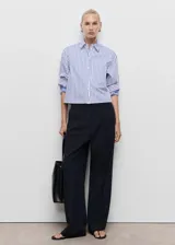 Pantalón de vestir de tiro bajo y diseño wide leg color azul marino, con pinzas en la parte delantera y bolsillos laterales.