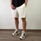 Short de algodón color beige melange, de diseño cómodo y holgado con bolsillos laterales y terminación descosida en las perneras.