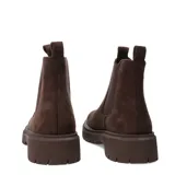 Botas Chelsea de mujer color marrón oscuro, estilo botín, con caña corta y paneles elásticos laterales. Cuentan con suela track gruesa y tiradores en el talón y la abertura frontal para facilitar el calce.