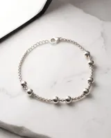 Pulsera de acero con baño de plata y esferas deslizantes decorativas intercaladas en una fina cadena.