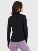 Chaqueta deportiva negra con cierre frontal completo, cuello alto y bolsillos laterales con cierre. Presenta mangas largas con aberturas para los pulgares y logo reflectante en el pecho.