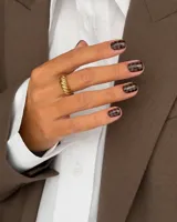 Anillo de acero dorado con diseño texturizado en relieve de bandas diagonales entrelazadas.