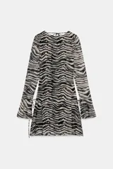 Vestido corto de tul con estampado animal print tipo cebra, escote barco y mangas largas acampanadas con lazadas ajustables. Cuenta con espalda abierta con detalle de lazada superior.