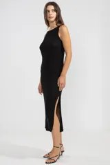 Vestido largo negro tejido en jersey con hilo lurex plateado, escote bote y corte con abertura lateral.