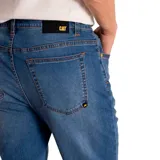 Pantalón de jean azul medio con corte slim, diseño clásico de cinco bolsillos, cierre de cremallera y botón metálico.
