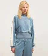 Suéter celeste de algodón felpudo con cuello alto, cremallera, mangas largas y detalles ajustados en los puños y bajo.