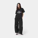 Remera de corte boxy fit color negro, con estampado gráfico frontal que incluye escudos y tipografía en color blanco.