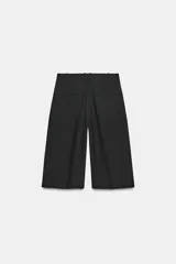 Bermuda larga color marrón oscuro, de tiro medio con cintura con trabillas. Presenta bolsillos laterales ocultos en la costura y detalle de raya planchada. Cierre frontal con cremallera, botón y ganchos metálicos.