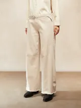 Pantalón de jean color crudo, de tiro alto y corte ancho (wide leg), con costuras contrastantes y terminación desflecada en el ruedo. Incluye un cinturón fino del mismo color.
