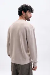 Buzo de tejido de punto color taupe, con cuello redondo y manga larga. Presenta una textura acanalada vertical.