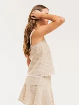 Top de lino a rayas verticales color beige con breteles anchos y ruedo con flecos.