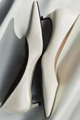 Zapato de tacón kitten fino en piel, color blanco, con escote redondo y acabado en punta.