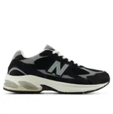 Championes urbanos New Balance, color negro con detalles en gris y blanco, confeccionados con capellada de malla y superposiciones de gamuza, con la característica 'N' en los laterales y entresuela amortiguada.