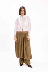 Blusa blanca de encaje con cuello mao, manga larga y cierre frontal con presillas y botones de tela.
