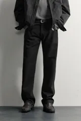 Jeans slim straight fit para hombre, confeccionados en denim de algodón negro sin lavados. Presentan diseño de tiro bajo, pierna recta y cinco bolsillos, con cierre frontal de botonadura.