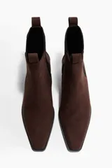 Botas Chelsea de gamuza color marrón oscuro, con punta cuadrada, elásticos laterales negros y taco cuadrado bajo.