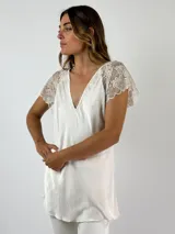 Top blanco de viscosa con escote en V y mangas cortas de encaje floral.