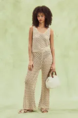 Pantalón beige de tejido calado con corte acampanado, cintura elástica e hilo metálico.