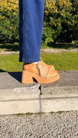 Zapatos de tacón alto y plataforma color camel, con inserción de cuero con textura en el empeine y doble cierre lateral decorativo.