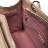 Cartera estructurada mediana color beige claro (hueso) de material símil cuero (PU) con forrería textil. Presenta doble manija fija, correa larga regulable y desmontable, solapa frontal con botón imantado y cierre superior con cremallera metálica.