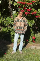 Buzo de paño con estampado azteca en tonos verde, marrón y beige. Tiene cuello alto de polar color crema y cierre de medio largo.