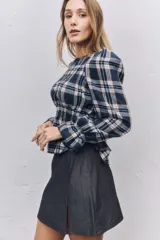Falda corta de jean color gris oscuro, con diseño de tiro alto y tajo lateral frontal.