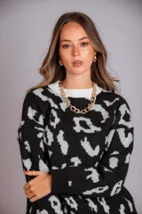 Buzo negro con estampado animal print en blanco, cuello redondo y mangas largas.