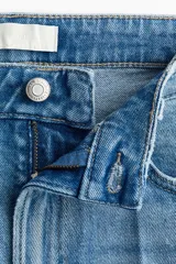 Jean tobillero de cinco bolsillos en denim de algodón con leve stretch, tiro alto y piernas rectas con pliegues frontales y posteriores.