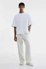 Remera blanca de algodón pesado, corte oversized, con cuello redondo ribeteado, hombros caídos y bajo recto.