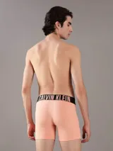 Pack de tres boxers tipo brief de algodón con cintura elástica distintiva de la marca Calvin Klein. Incluye un modelo negro, uno blanco y uno color salmón, todos con el logo estampado en la banda elástica.