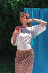 Top marrón de viscosa con escote bote, mangas murciélago tres cuartos y ajuste drapeado en la cintura.
