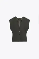 Chaleco de corte sastrero en color gris oscuro, con escote en V, cierre frontal con botones y cintura entallada. Presenta mangas cortas con diseño amplio y forro interior.