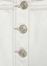 Chaleco estilo denim de corte crop, confeccionado en algodón. Presenta escote cuadrado, cierre frontal con botones metálicos y dos bolsillos con solapa en el pecho.