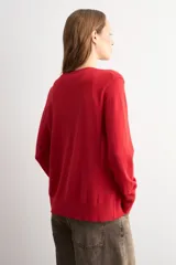 Cardigan de punto fino color negro, con cuello redondo, cierre frontal de botones y mangas largas.