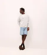 Bermuda de corte recto confeccionada en denim de algodón, con cintura con trabillas, cierre tradicional de botón y cremallera, y bolsillos funcionales.
