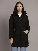 Campera Calvin Klein tipo walker acolchada y de acabado mate color negro, con diseño largo, mangas largas, cierre frontal con cremallera y bolsillos laterales con cierre. Incluye capucha con forro de sherpa interior.