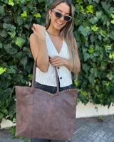Bolso tipo shopper grande de cuero marrón caoba, con costuras decorativas entrelazadas en el borde superior y doble asa de hombro.