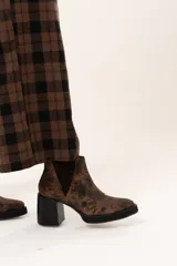 Bota tipo chelsea de cuero con acabado texturizado efecto desgastado en color chocolate. Presenta paneles laterales elásticos, suela de plataforma y taco cuadrado robusto en color negro.