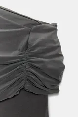 Body azul marino de escote asimétrico con un hombro descubierto, detalle de frunces en el busto y cierre de botones a presión en la parte inferior.