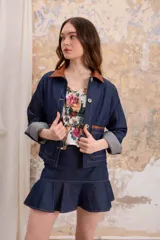 Sobrecamisa de jean liviano con cuello de cuero marrón, corte recto y bolsillos delanteros con ribete de cuero.