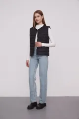 Chaleco acolchado color verde militar con cierre de botones a presión.