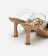 Mules de tacón alto con punta fina, confeccionados en tejido de red con aplicación de strass. Presentan una tira transparente de vinilo en el empeine y un diseño abierto en el talón.