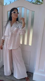 Camisa de corte holgado confeccionada en popelina a rayas verticales blancas y celestes. Presenta cuello clásico, cierre frontal con botones de nácar, mangas largas con puños y un bolsillo aplicado en el pecho izquierdo.